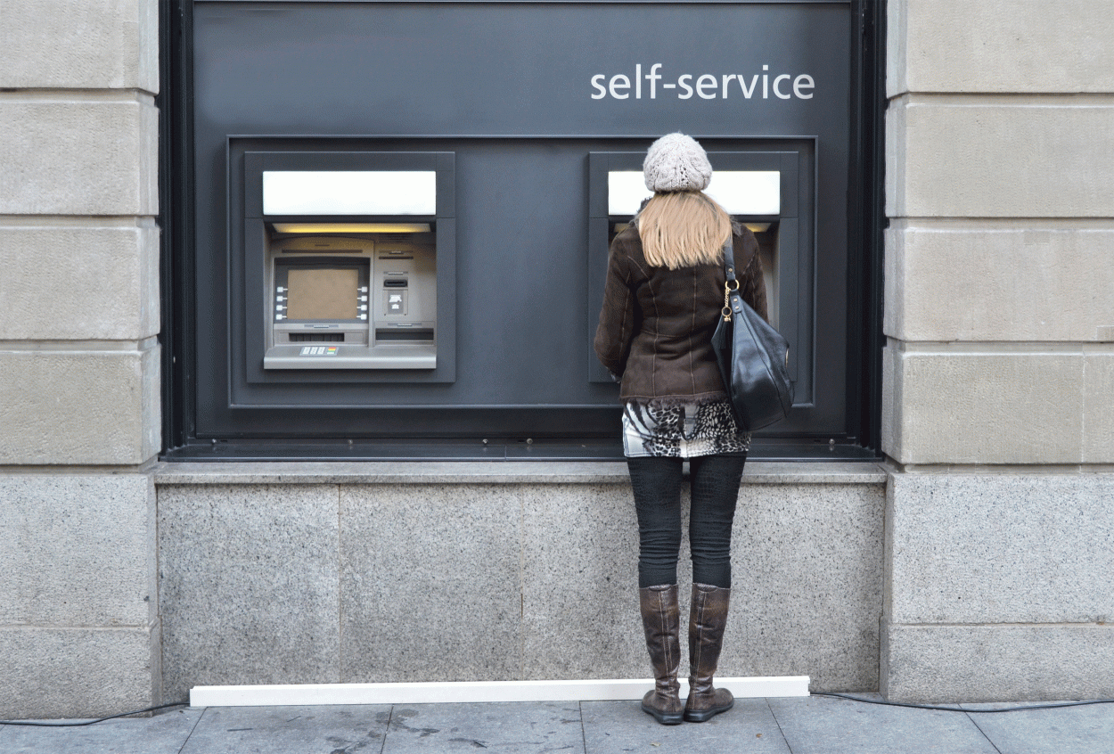 A woman standing in front of an ATM machine
